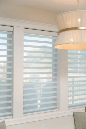 White blinds on windows around the kitchen space.