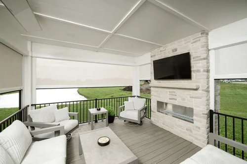 Automatic white outdoor roller shades that surround the patio.