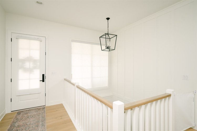 Indoor roller shades above a staircase.