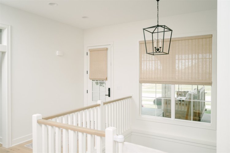 Indoor roller shades in a white entrance space.